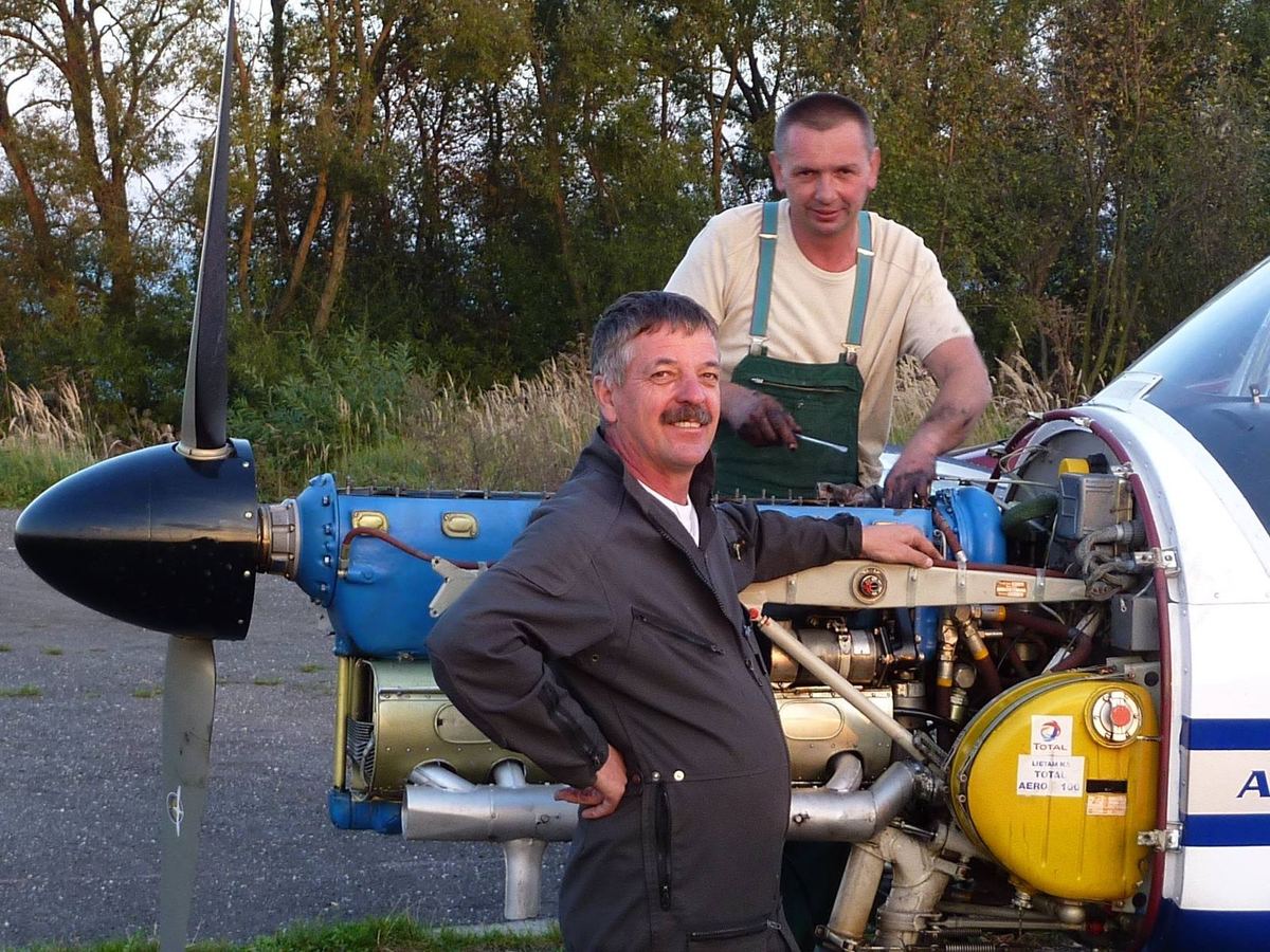 Dvaja mechanici pri odkrytom motore lietadla Zlín