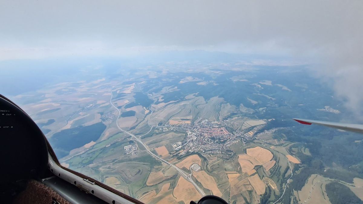 A historic town with red roofs and a motorway, seen from a glider