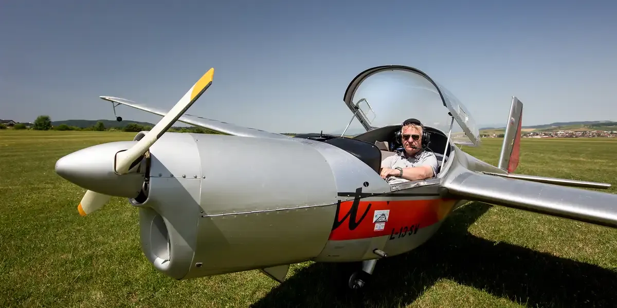 Motorový klzák L-13 SE Vivat s pilotom v kabíne na letisku